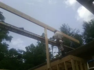 Carpenter setting a ridge beam over a new addition frame — Ice Dam Removal by Roofing Brothers in Falls Of Rough