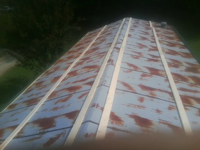 Rusted metal roof panels with new wood purlins before replacement — Storm Damage Roof Repair in Falls Of Rough by Roofing Brothers